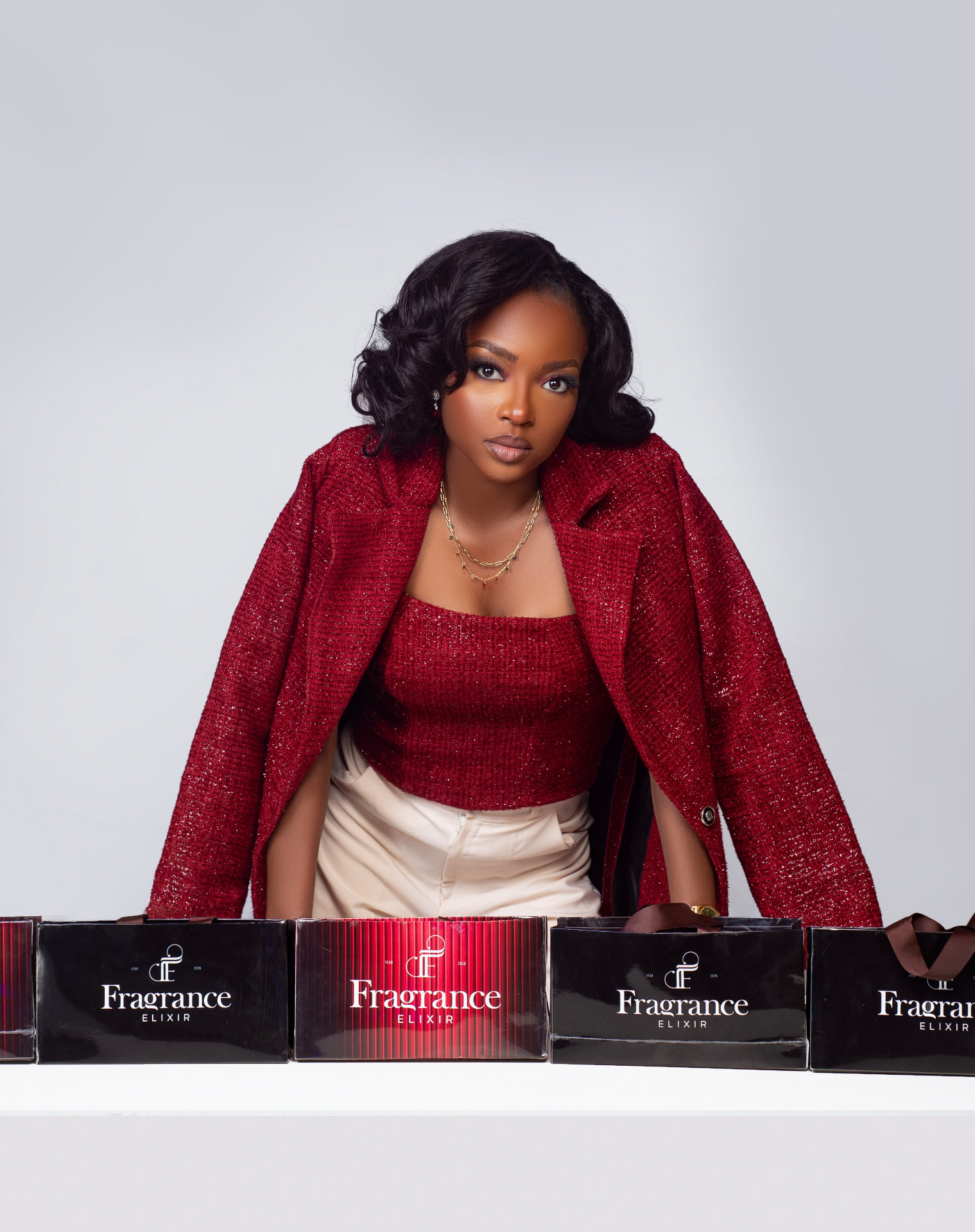Fragrance Elixir founder with Fragrance Elixir gift boxes in warm studio light